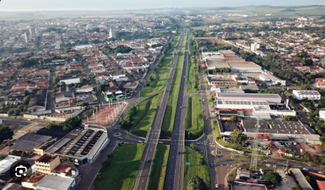 Fotografia de uma rua movimentada em Leme, com empresas e pessoas em atividade